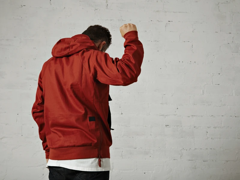 young-fit-male-model-brick-red-sports-jacket-holds-his-fist-up-air-portrait-from-back-isolated-white 1